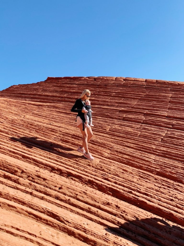 People hiking through a red rock canyon in Zion National Park, showcasing the adventurous activities and natural beauty of the area.