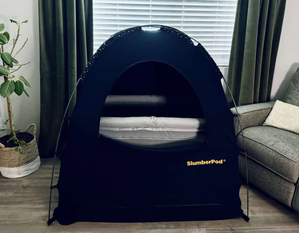 SlumberPod privacy cover successfully fitted over the Newton Travel Crib, illustrating compatibility for darkened sleep environments while traveling.