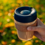 Close-up of KeepCup glass reusable cup with a black lid, showcasing its sleek design and the clarity of the glass.