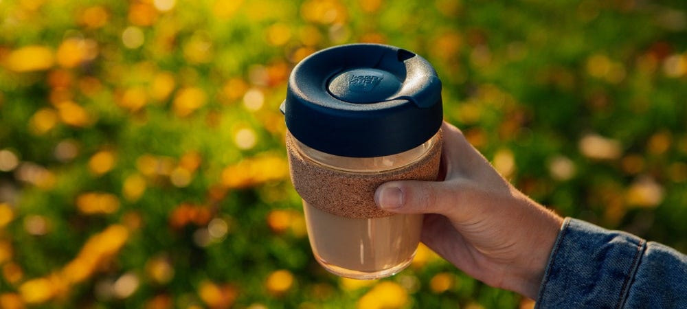 Close-up of KeepCup glass reusable cup with a black lid, showcasing its sleek design and the clarity of the glass.