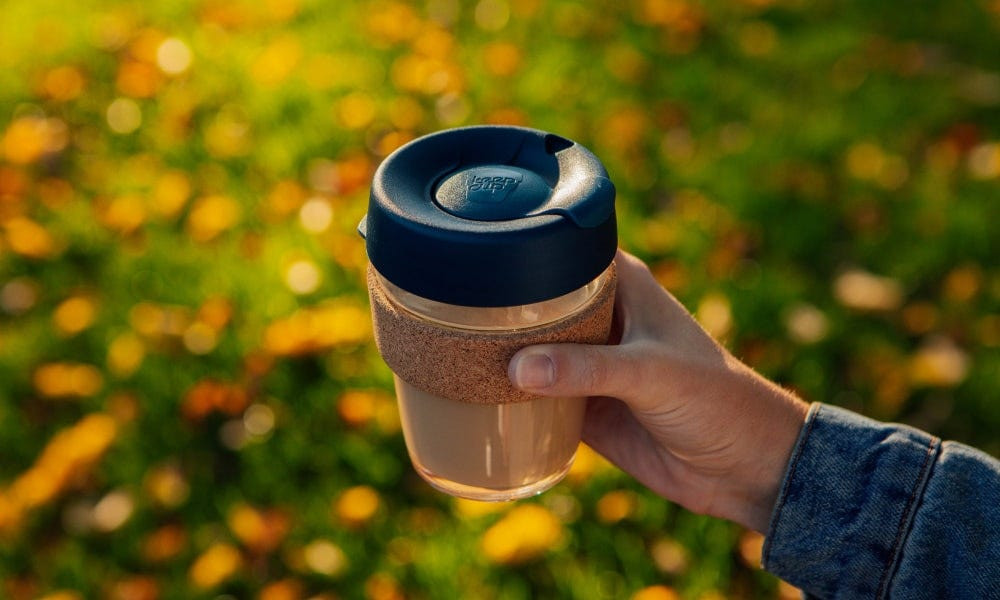 Angle shot of the KeepCup Brew Cork, highlighting the cork band and the lid, set against a bright background to emphasize its design features.