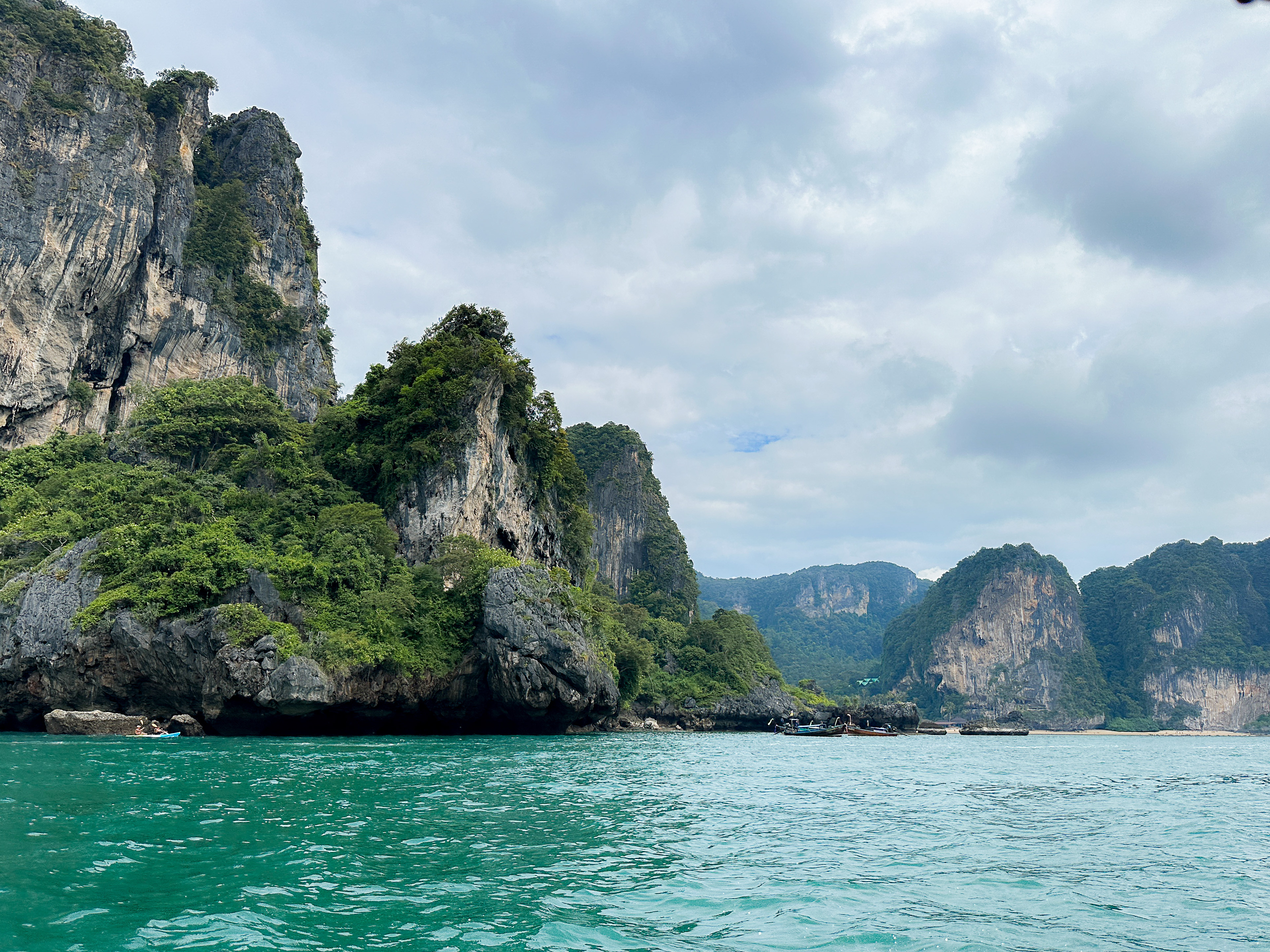 Panoramic view of Railay Beach, Krabi, Thailand, with limestone cliffs, white sand, and turquoise water.