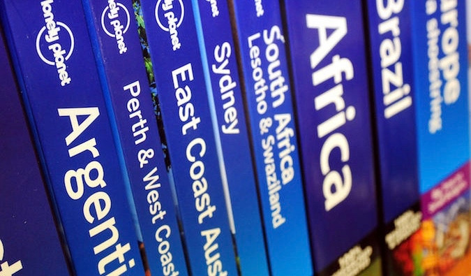 Shelves filled with Lonely Planet travel guide books, illustrating the once ubiquitous nature of these guides for travelers.