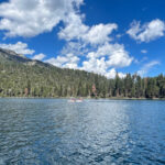 Emerald Bay in Lake Tahoe, California, with clear blue water surrounded by green trees and mountains.