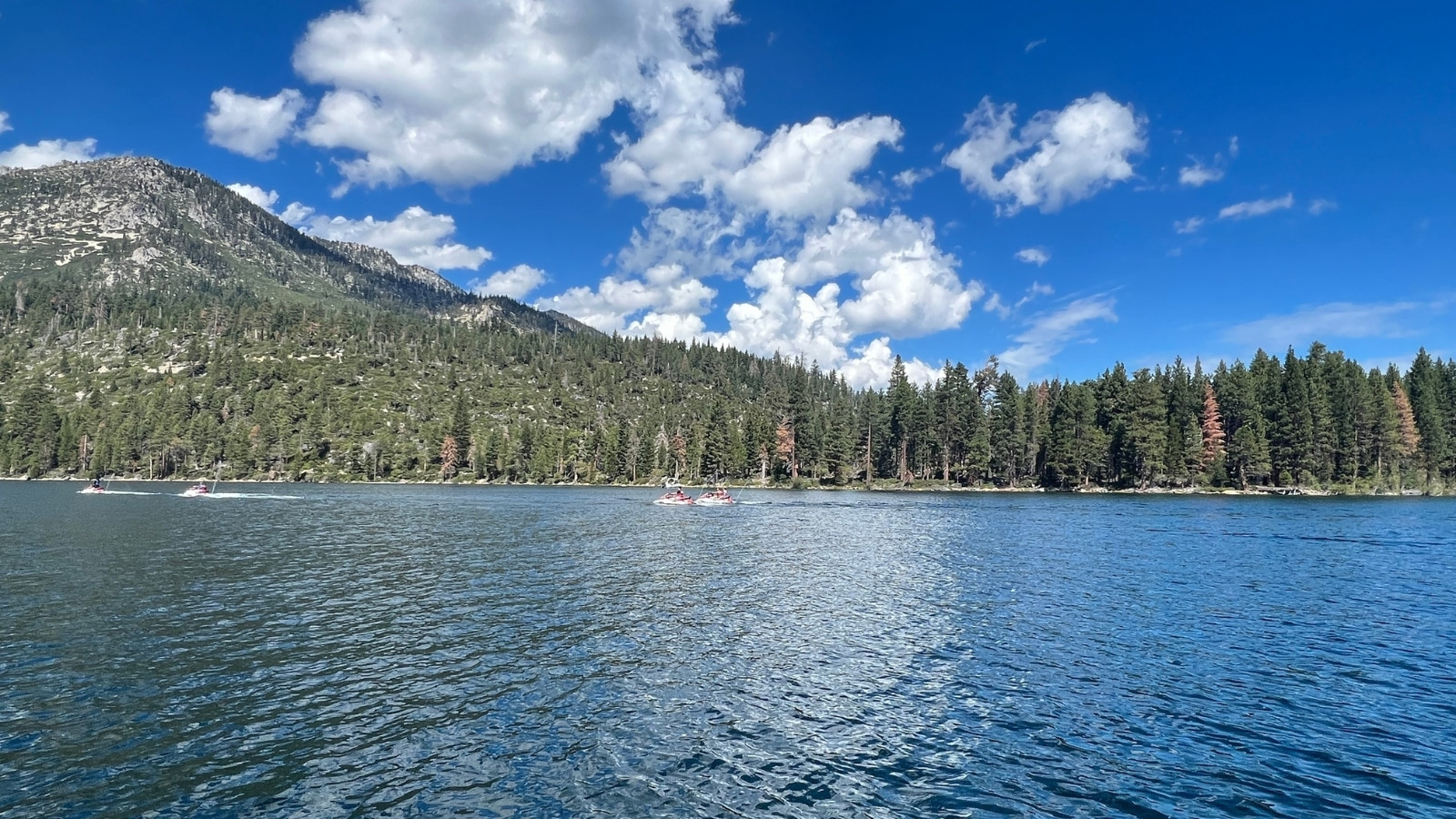 Emerald Bay in Lake Tahoe, California, with clear blue water surrounded by green trees and mountains.