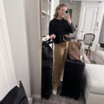 Woman in comfortable yet stylish travel attire, featuring a cozy sweater and trousers, perfect for long flights.