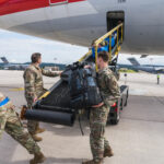 U.S. Air Force personnel load luggage onto a commercial aircraft during Operation Allies Refuge, highlighting the collaboration between military and civilian aviation for passenger transport.