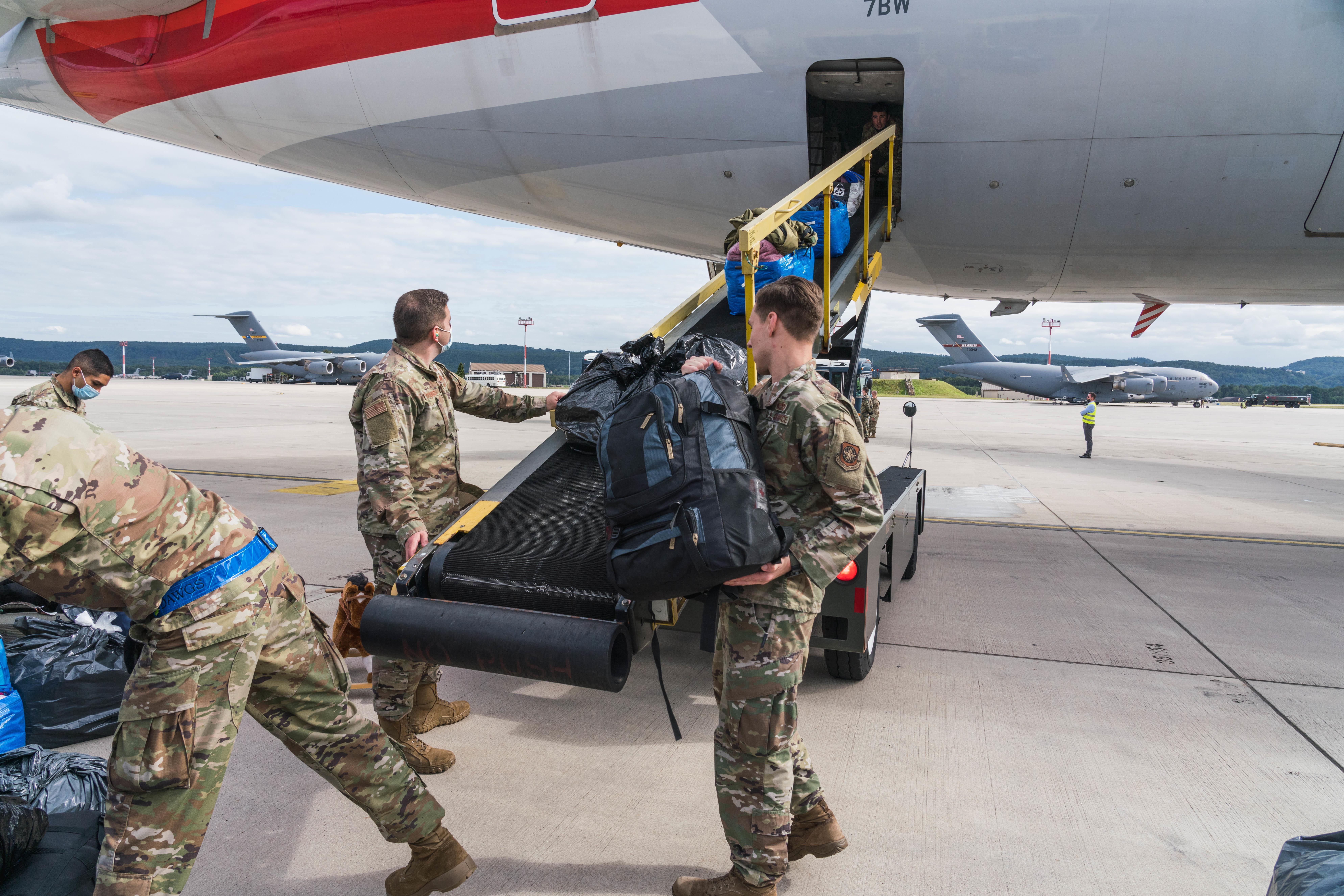 U.S. Air Force personnel load luggage onto a commercial aircraft during Operation Allies Refuge, highlighting the collaboration between military and civilian aviation for passenger transport.