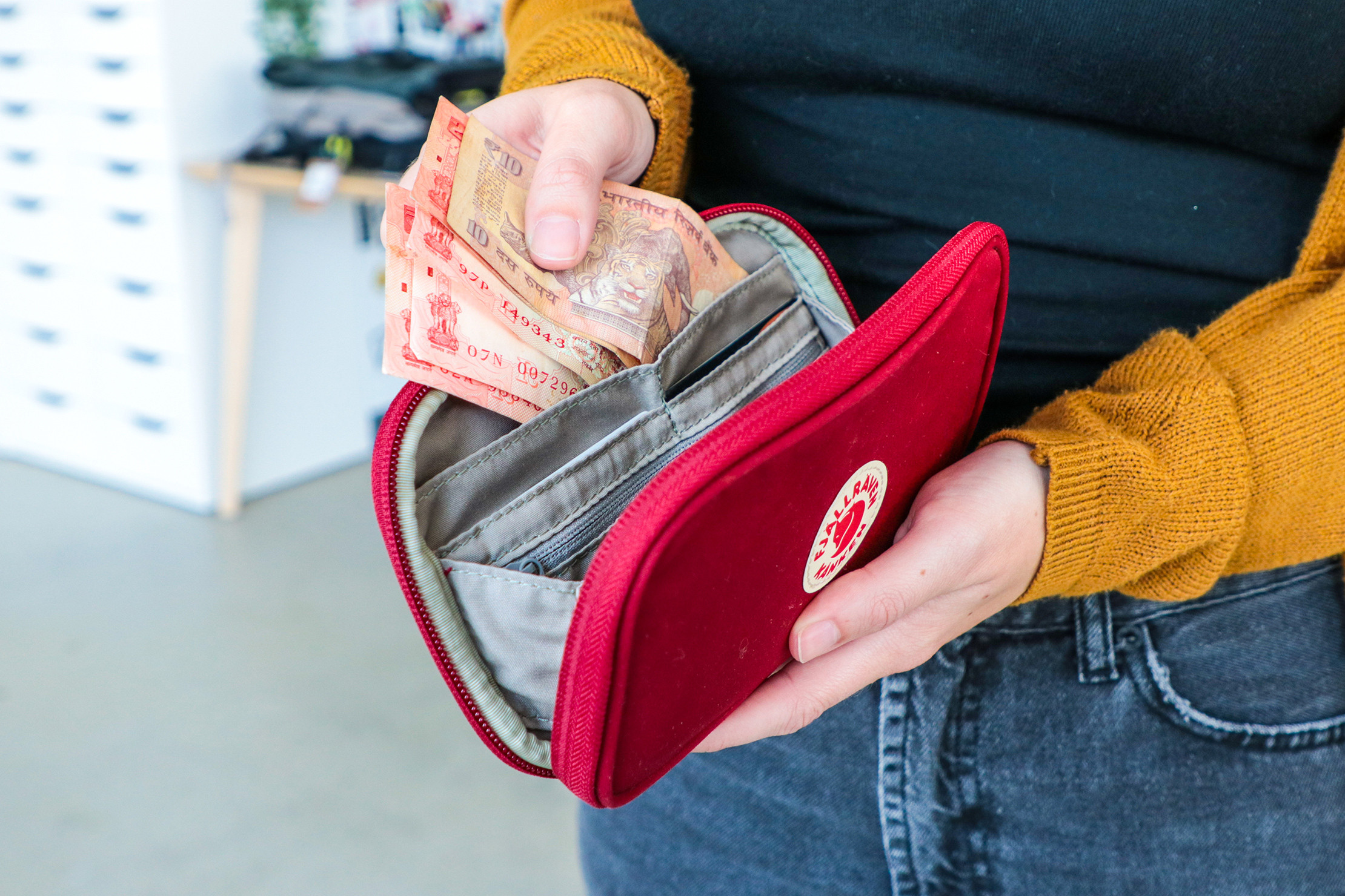 Fjallraven Kanken Travel Wallet Review for Men:  In use, highlighting its sustainable materials and versatile design for environmentally conscious male travelers.