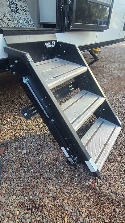 Lippert SolidStep RV steps folded up against the trailer door, showing the base plate