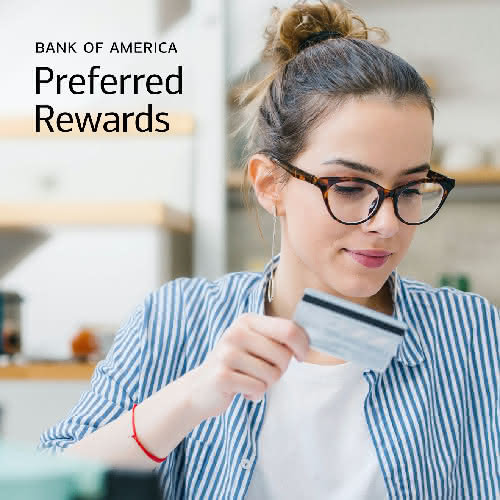Woman holding a credit card, suggesting travel planning and financial readiness.