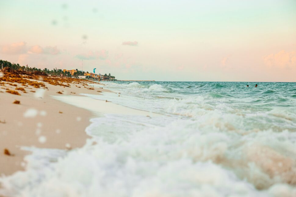 turquoise waves of a Playa del Carmen beach near sunset on a clear day