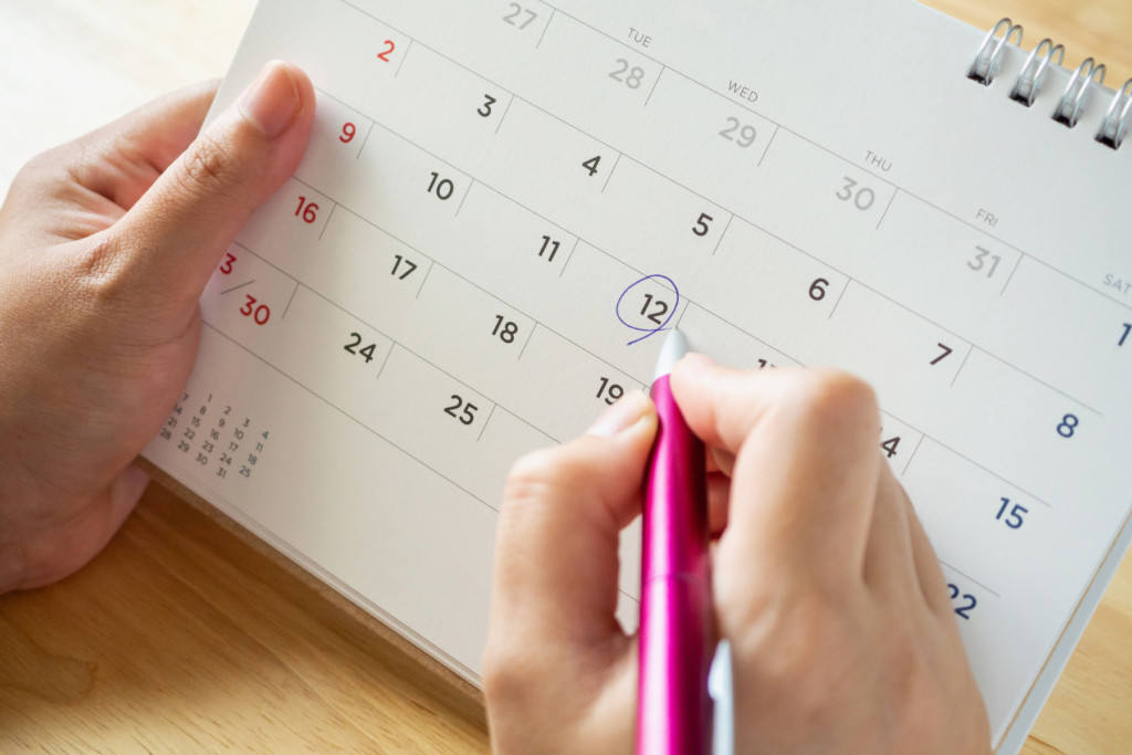 Person circling dates on a calendar