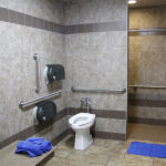 A clean and brightly lit shower room at a Love's Travel Stop, featuring a tiled shower stall and a wooden bench, emphasizing the comfort and cleanliness available to travelers.