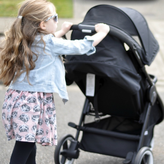 Mother with her baby in the Cybex Agis car seat, preparing for a car ride