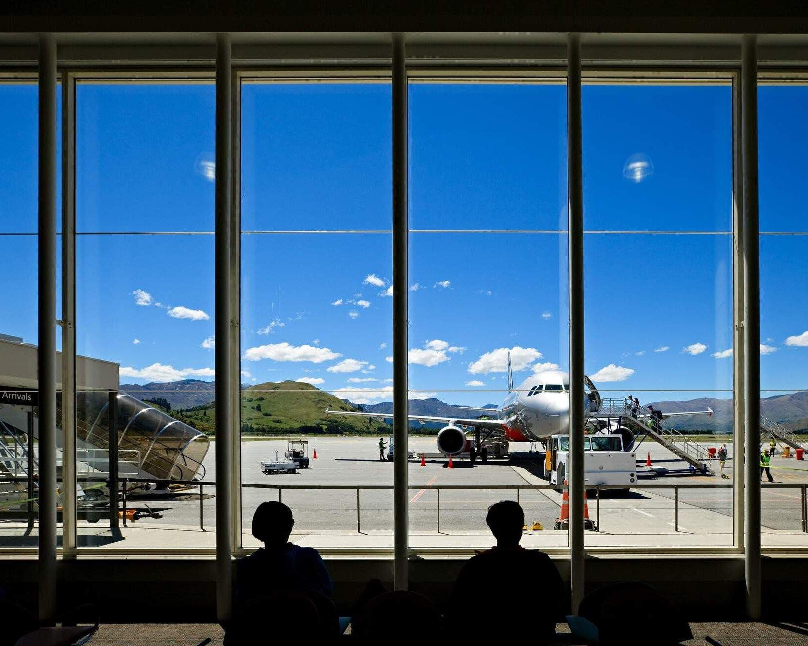 View of airport through window and silhouette of people