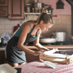 A woman happily cooking alone, embodying the fun and independence of solo travel.