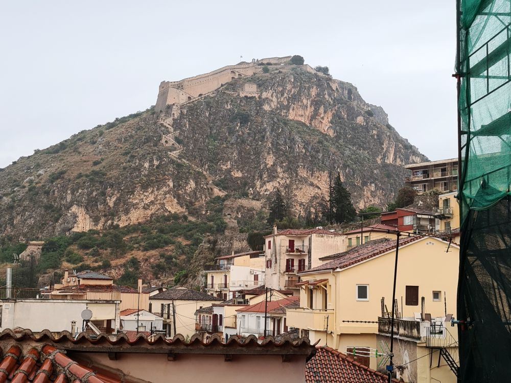 A fortress tops a steep hill, and a stairway zigzags its way down the side.