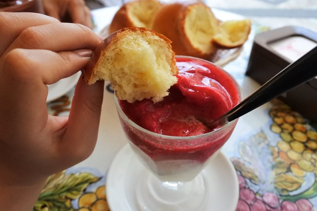 A vibrant display of granita flavors, including lemon and almond, served with brioche.