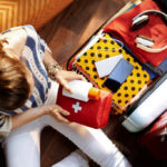 Woman packing first aid kit in her luggage