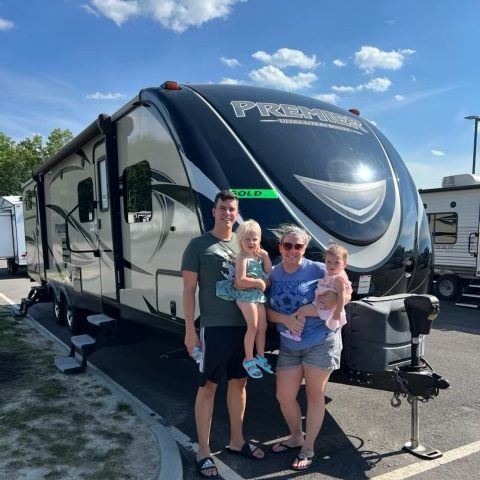 The family stands in front of their RV, ready for their next adventure.