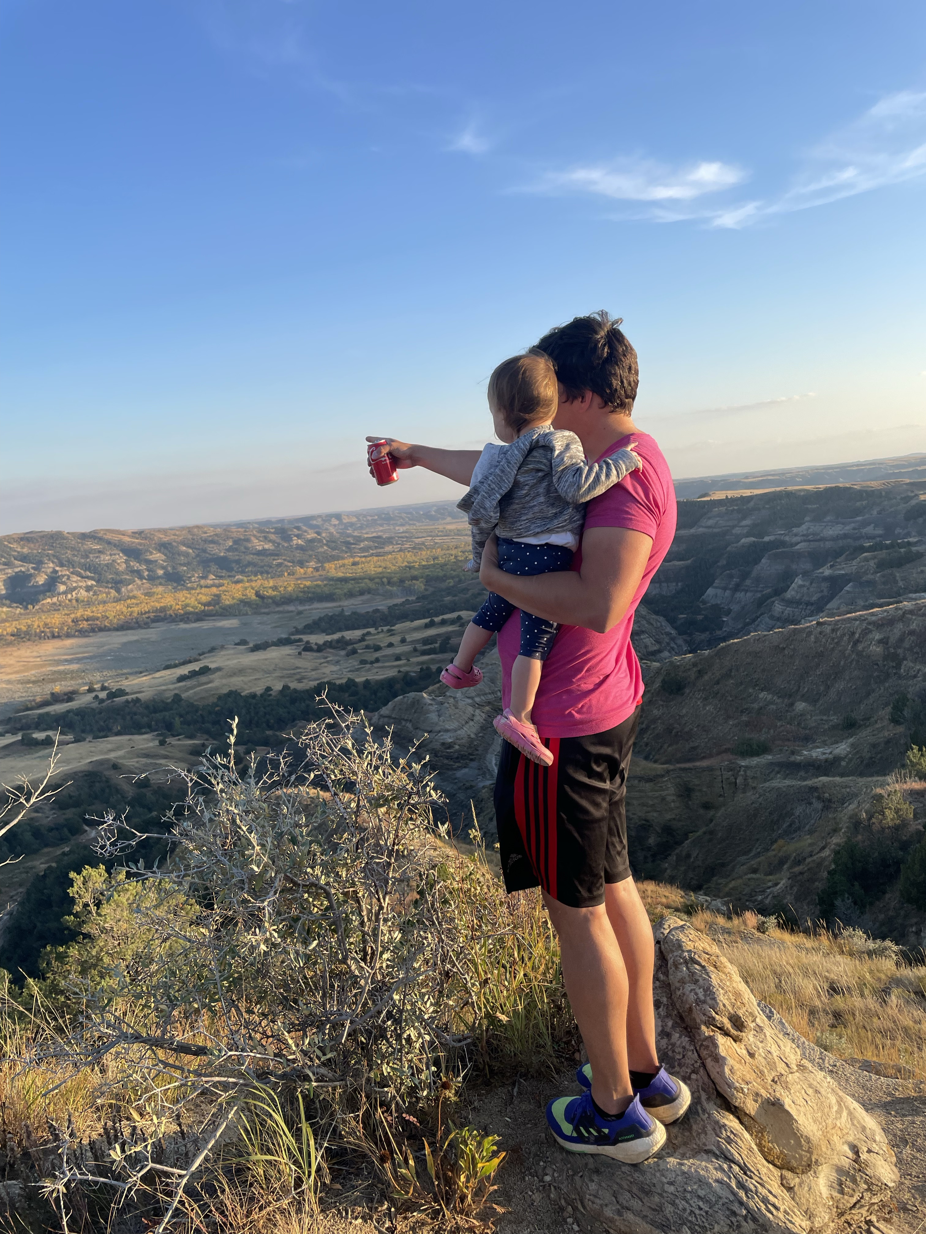Alex and her family posing in front of a scenic mountain view during their travels.