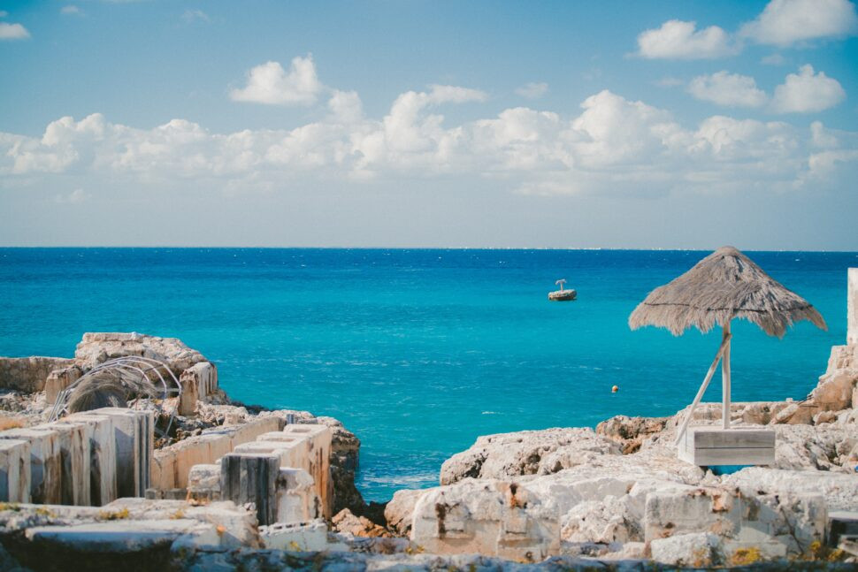 A tranquil Cozumel shore with a boat off in the distance on a sunny day