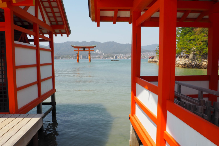 Visitors walking around Itsukushima Shrine on Miyajima Island, Japan, at high tide.