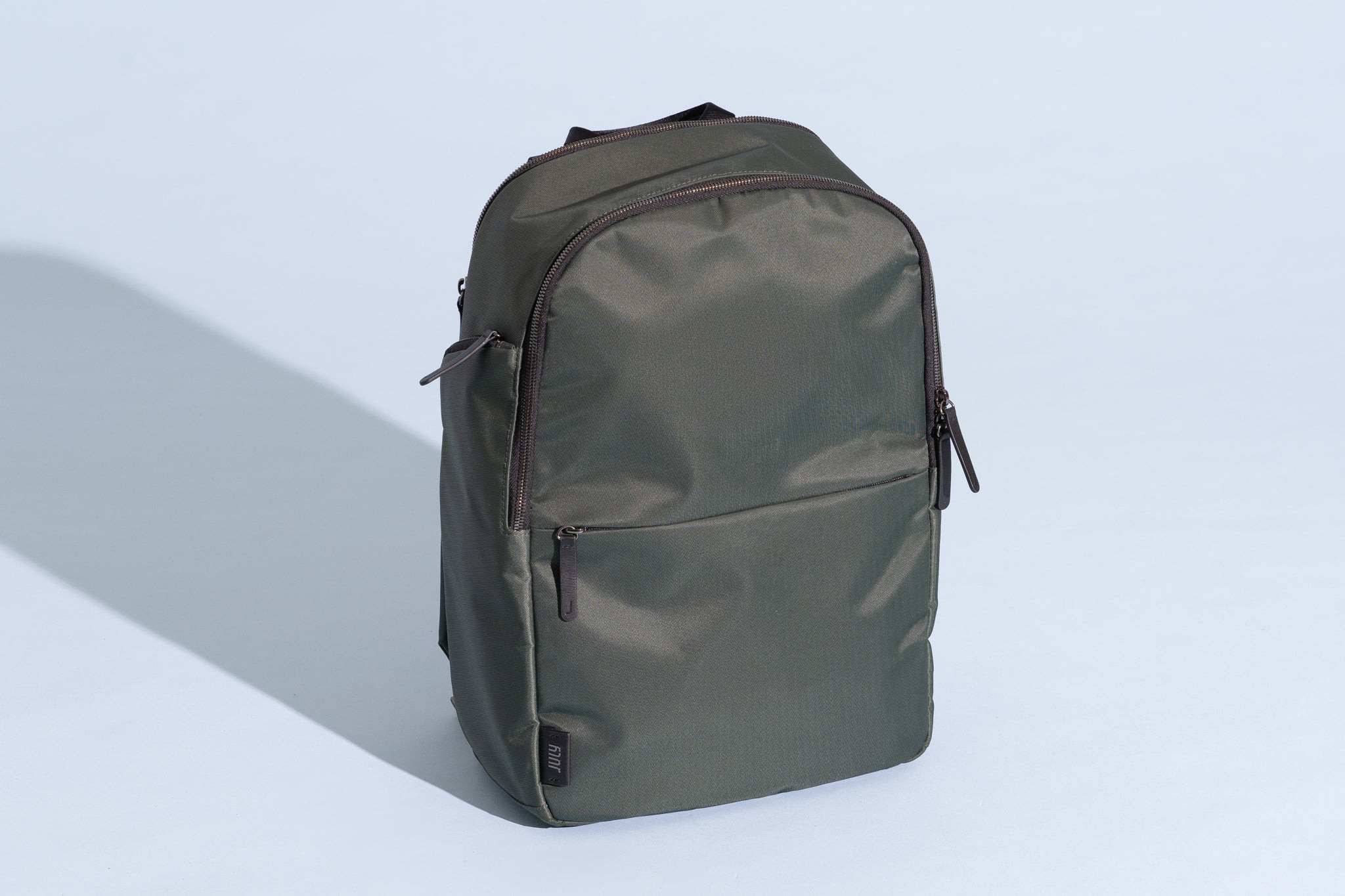 July Carry All Backpack 20L showcasing its sleek design and leather accents, perfect for modern travelers.