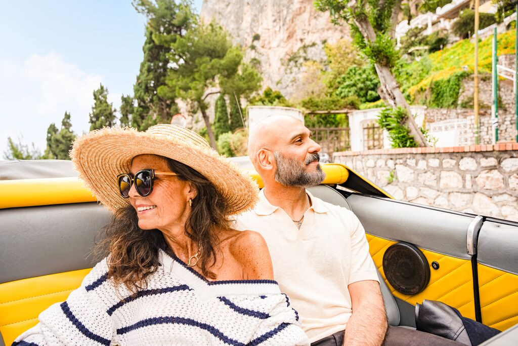 Couple enjoying an open-top car ride in Capri