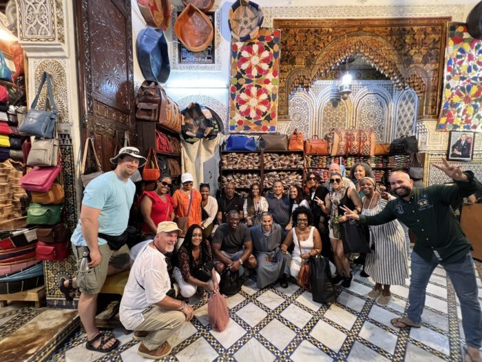 A group browsing leather goods in a Moroccan shop, showcasing the variety of local crafts
