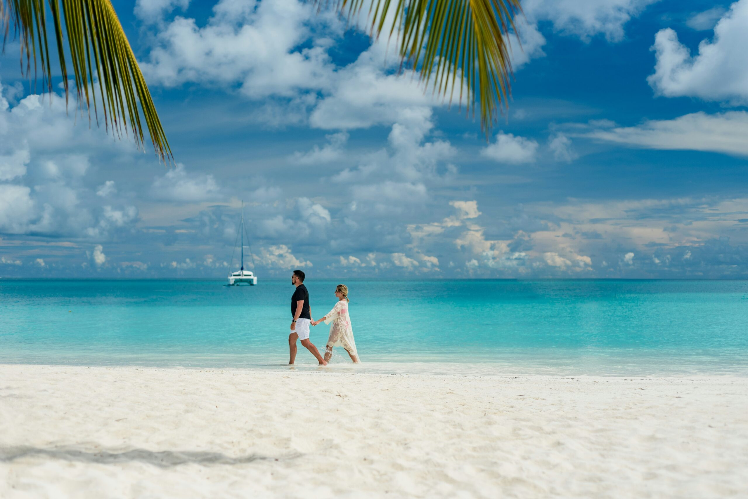 Couple walking hand-in-hand on a Maldives beach