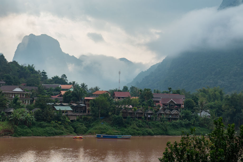 Village by the river in Nong Khiaw, Laos, a budget-friendly outdoor adventure destination.