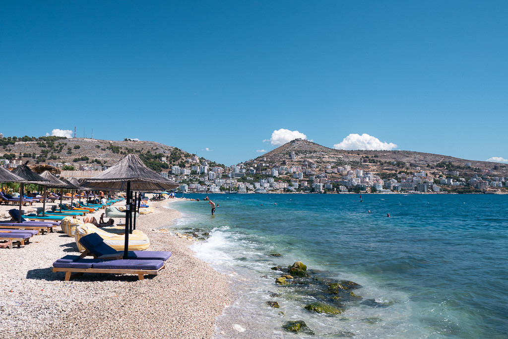 Serene beach scene in Albania with clear turquoise waters and white sand