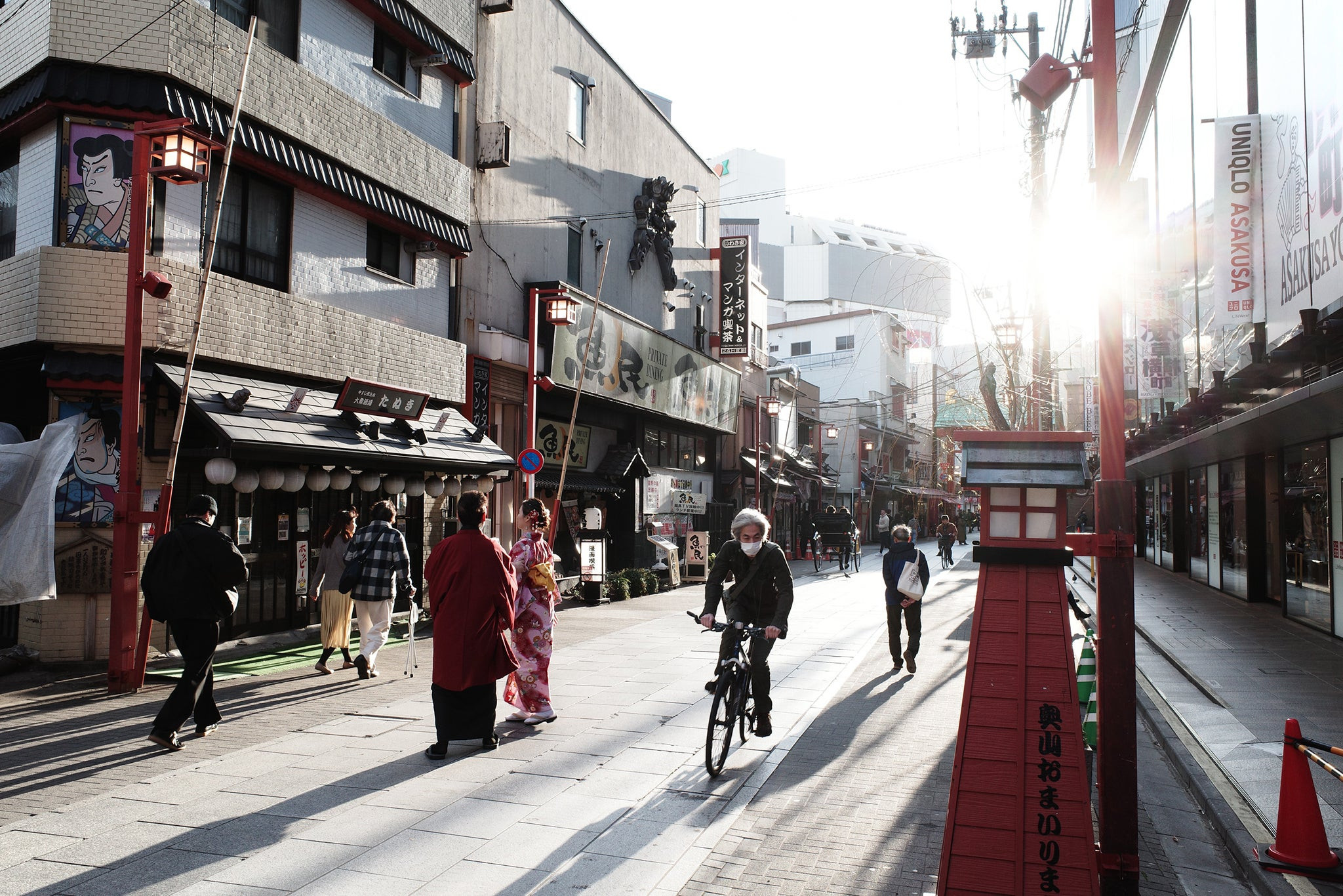 A street scene captured with the Ricoh GR III showcasing a cyclist and pedestrians, highlighting the camera's ability to capture candid travel moments