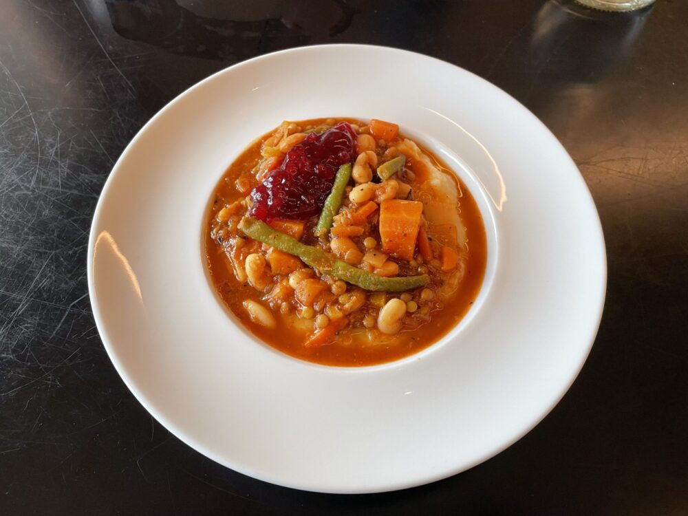 A bowl of hearty stew with veggies and beans served over mashed potatoes at Priekestolen Basecamp, near Stavanger, Norway. Photo: Ryan Damm
