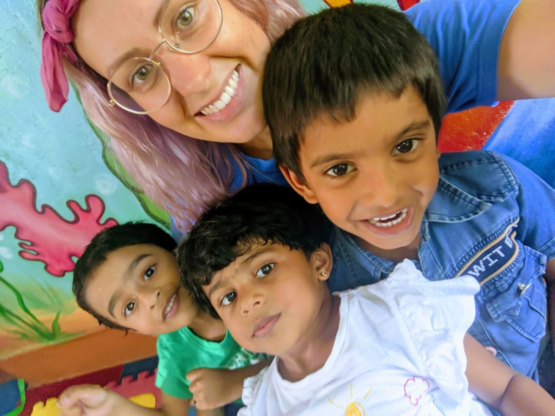 Two volunteers painting a mural in a vibrant location, showcasing the work exchange aspect of Worldpackers and the opportunity for free travel