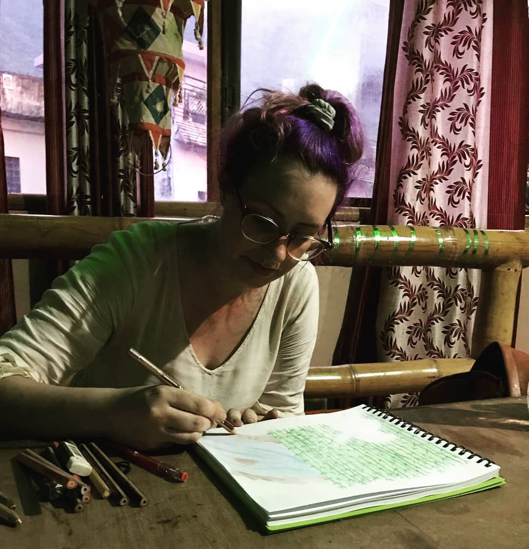 A person working on a laptop at a cafe in a foreign city, representing the digital nomad lifestyle and earning money while traveling