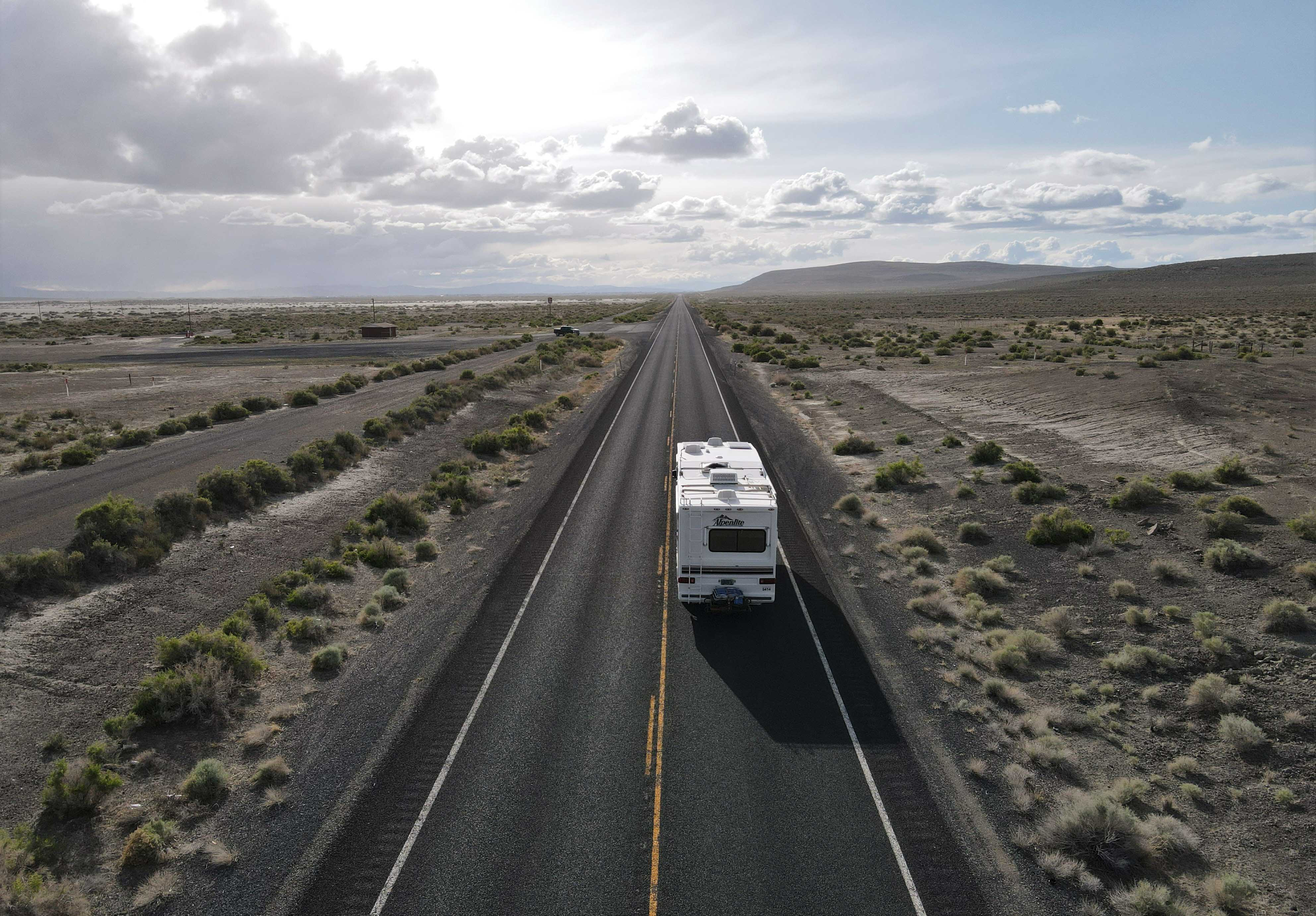 RV bus driving west on a back road