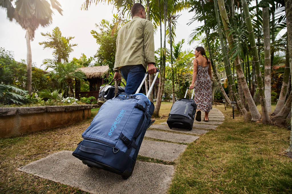 Travelers with rolling luggage in an airport