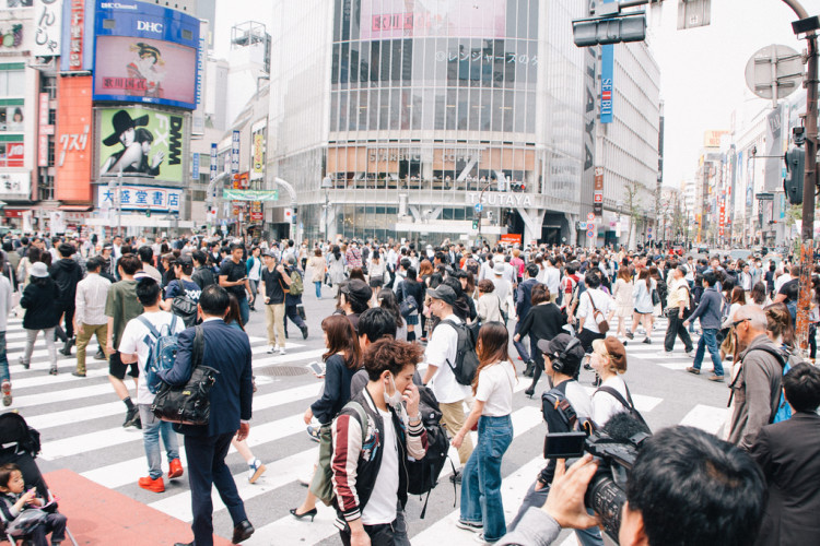 The iconic Shibuya Crossing in Tokyo, bustling with pedestrians and bright lights.