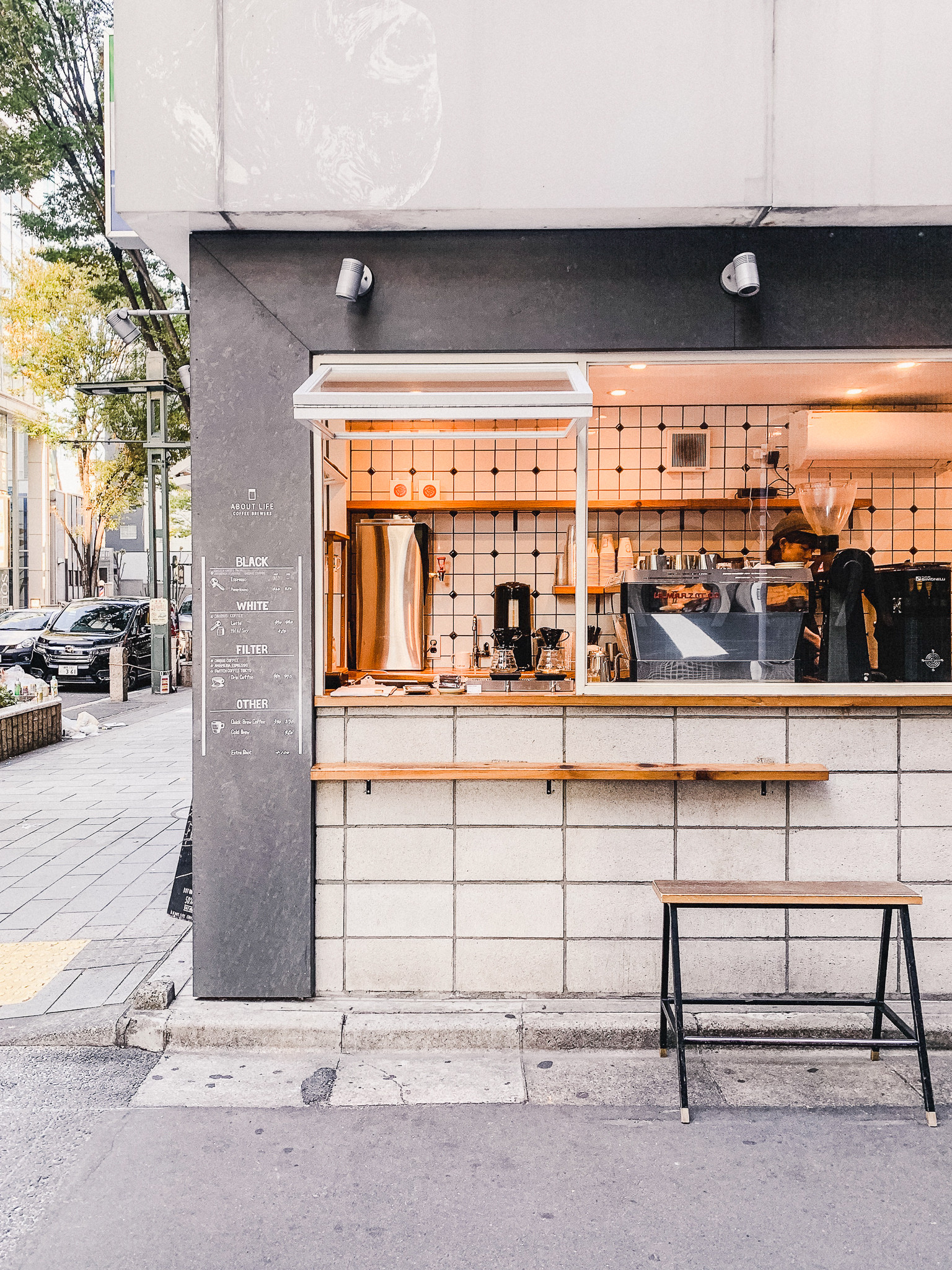 An assortment of freshly baked pastries and desserts displayed on a wooden shelf in a Tokyo bakery, showcasing the tempting treats available alongside coffee.