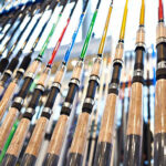 Various fishing rods displayed in a store, highlighting the different types and colors available for anglers.