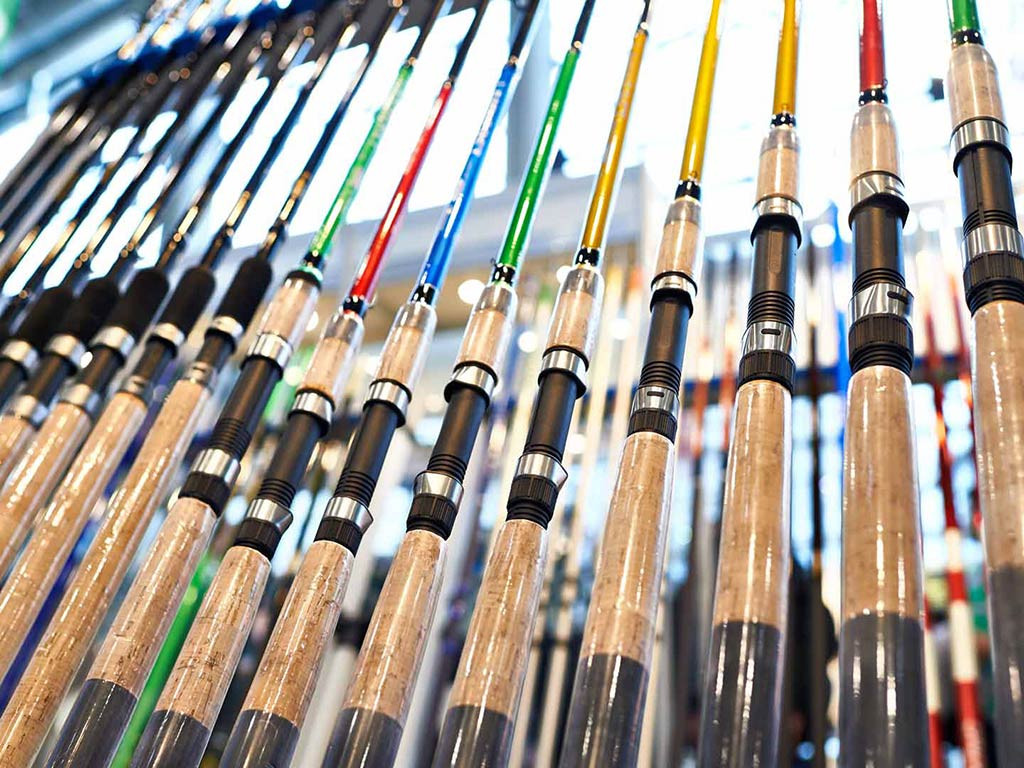 Various fishing rods displayed in a store, highlighting the different types and colors available for anglers.
