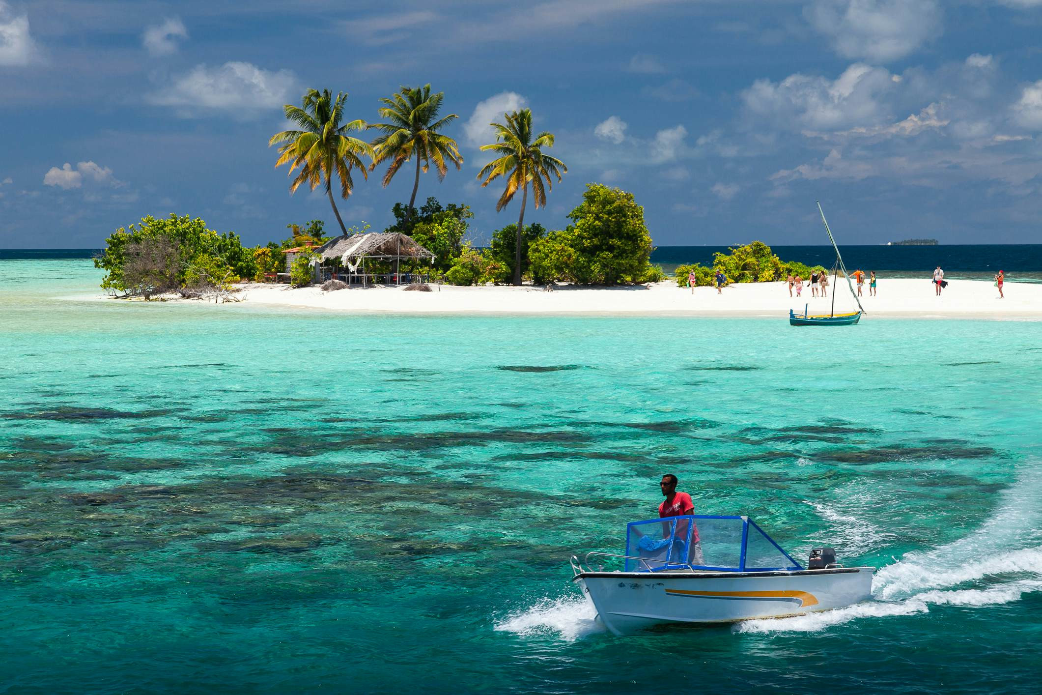 A speedboat leaving a tiny island in the Maldives