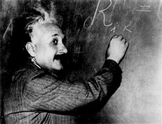 Albert Einstein writing on a blackboard, symbolizing his work on special relativity and light speed