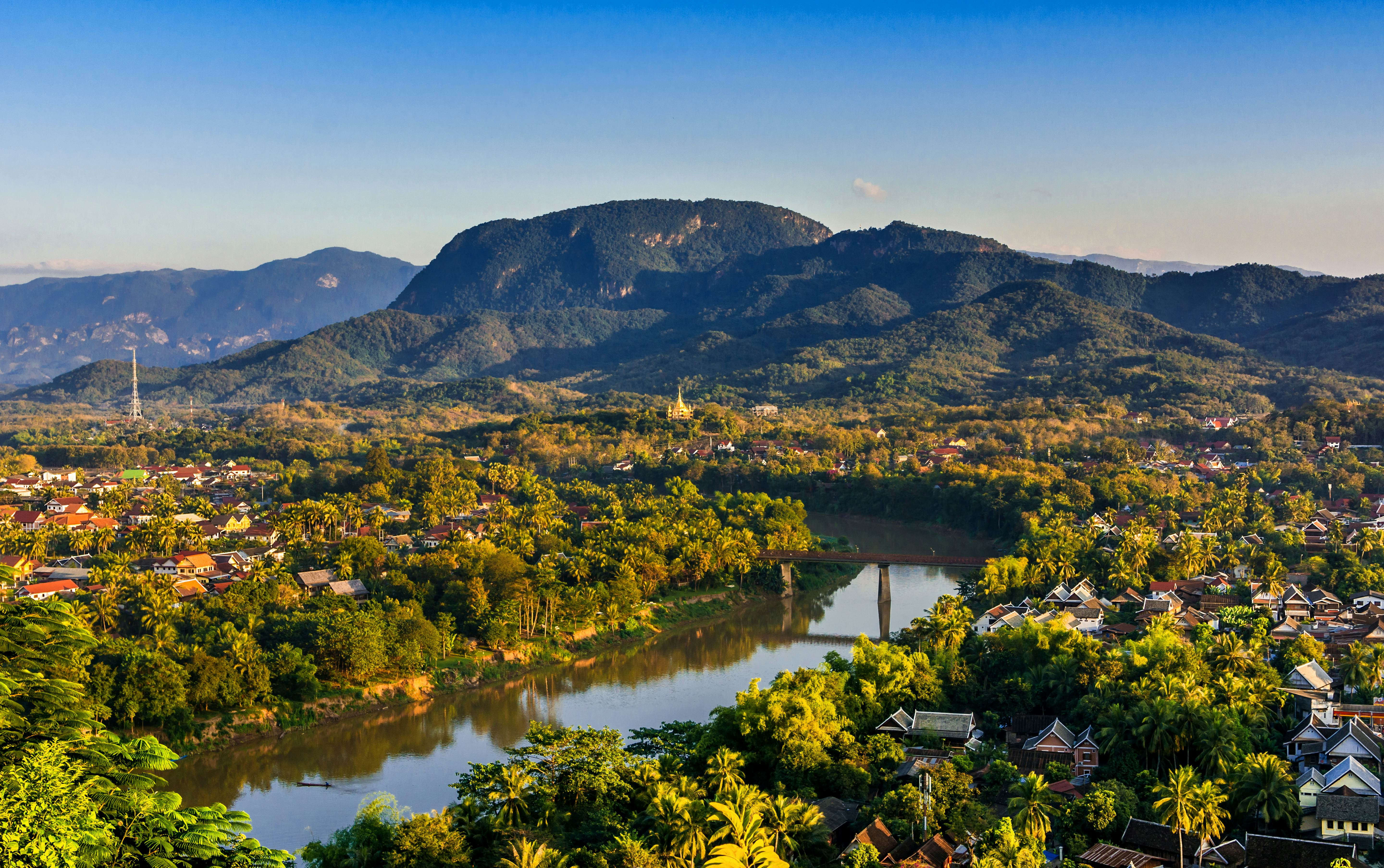Sunset over Luang Prabang at the confluence of the Mekong and Nam Khan rivers, with hills in the distance
