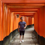 Nomadic Matt walking under torii gates in historic Kyoto, Japan