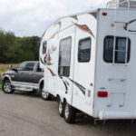 Pickup truck backing up large 5th wheel camper Cougar