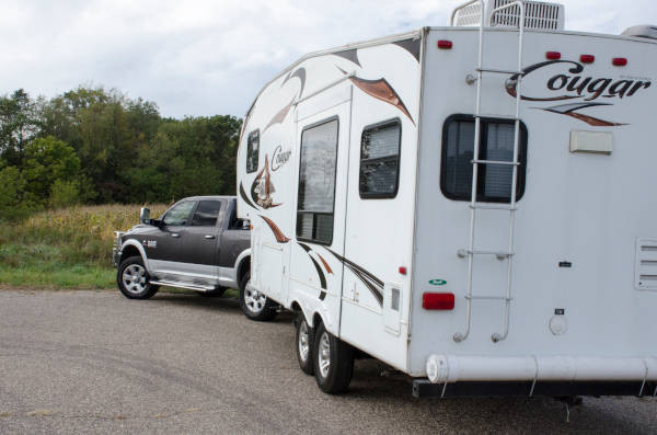 Pickup truck backing up large 5th wheel camper Cougar